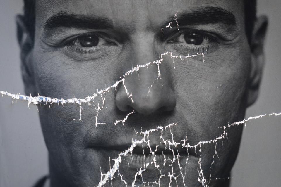 FILE - A partially damaged poster of Spanish Prime Minister and Socialist Party candidate Pedro Sanchez flaps in Parla, outskirts Madrid, Spain, April 26, 2019. Spanish Prime Minister Pedro Sánchez says that he will consider resigning after what he calls “spurious” corruption allegations against his wife led to a judicial investigation being opened on April 24, 2024. Sánchez said in a letter posted on his X account that while the allegations against his wife Begoña Gómez are false, he is canceling his public agenda until Monday when he announce whether he will continue or step down. (AP Photo/Bernat Armangue, File)