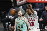 Chicago Bulls center Daniel Gafford (12) dunks the ball over Charlotte Hornets center Bismack Biyombo while forward Gordon Hayward (20) looks on during the second half of an NBA basketball game in Charlotte, N.C., Friday, Jan. 22, 2021. (AP Photo/Jacob Kupferman)