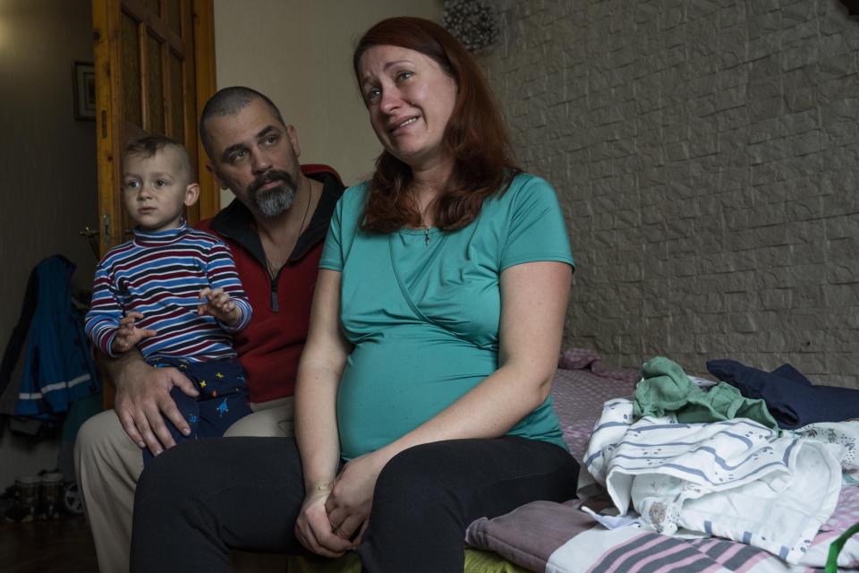 Dr. Marta Kopan, weeps as she recalls her story fleeing from their home in Kyiv, with her husband Dr. Maxim Motsya, and their 3-year-old son Makar, at an apartment given to them by a cousin, in Lviv, western Ukraine, Sunday, April 3, 2022. Marta is also 38 weeks pregnant. The place in Kyiv where she meant to give birth was bombed. Her birth plan, like almost everything else, was left behind. (AP Photo/Nariman El-Mofty)