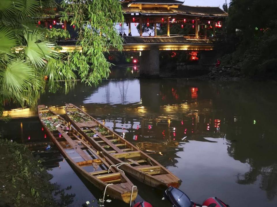 Two dragon boats that capsized, killing seventeen people, sit in the water on the Taohua River in Guilin in southern China (Chinatopix via AP)