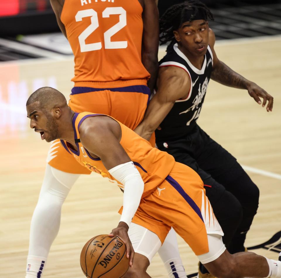 The Suns' Chris Paul drives past the Clippers' Terance Mann after getting a screen from Deandre Ayton in Game 3.