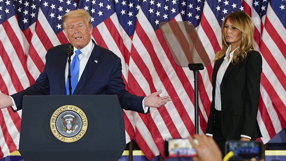 President Donald Trump and First Lady Melania stand together on stage at an election night party.