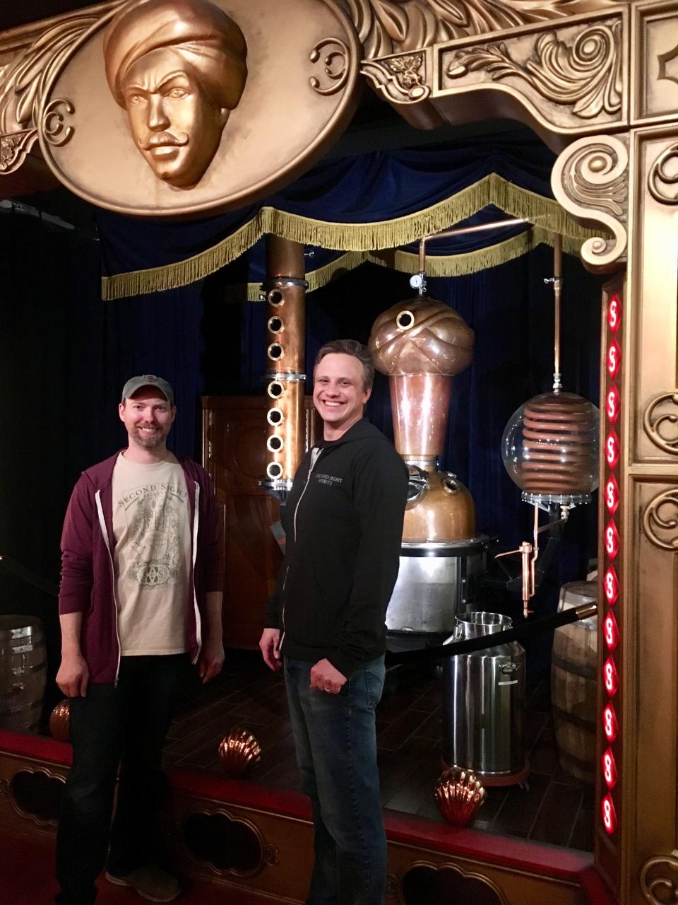 Carus Waggoner and Rich Couch pose near a still that they designed and built for their distillery, Second Sight Spirits.