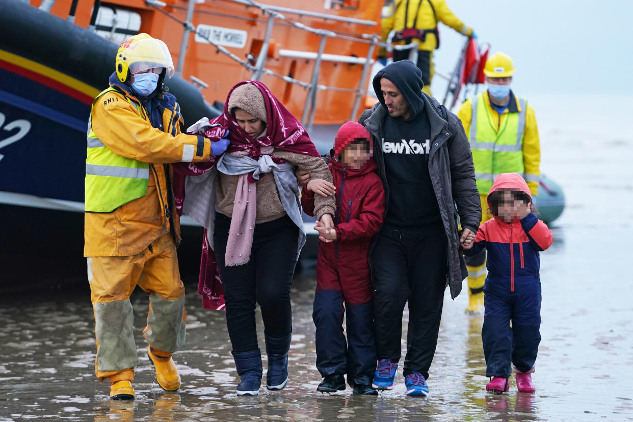 EDITORS NOTE Children's faces have been pixelated as the PA Picture Desk has been unable to gain the necessary permission to photograph a child under 16 on issues involving their welfare. People thought to be migrants are helped ashore by lifeboat crew members, after arriving on a dinghy at a beach in Dungeness, Kent. Picture date: Saturday November 20, 2021. (Photo by Gareth Fuller/PA Images via Getty Images)