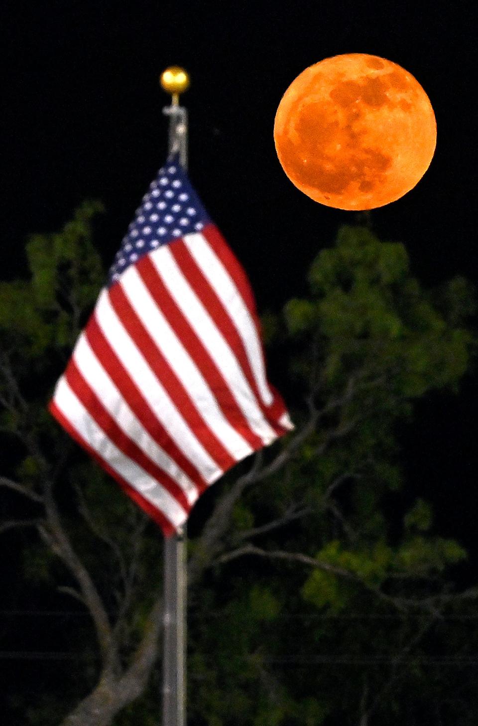 The full moon rises beyond the flagpole at McMurry University in Texas on May 23, 2024.