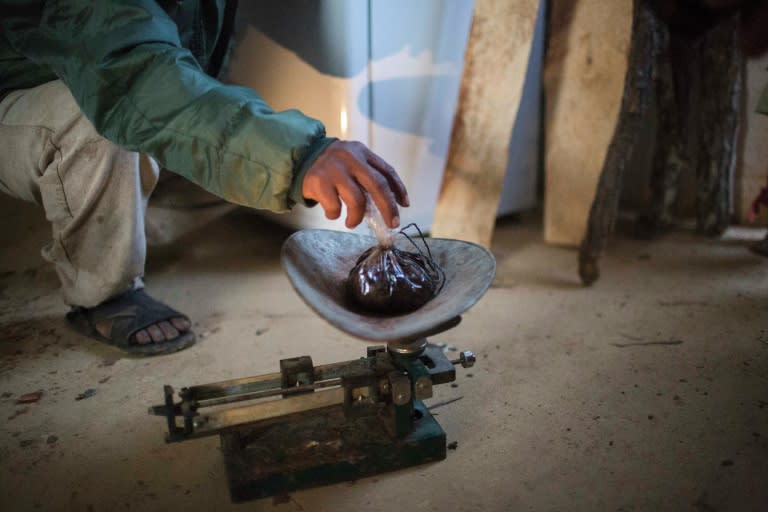 A man weighs opium gum extracted from its poppy field in Guerrero State, Mexico