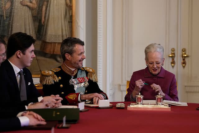 <p>MADS CLAUS RASMUSSEN/Ritzau Scanpix/AFP via Getty </p> Queen Margrethe II of Denmark (right) signs a declaration of abdication as Crown Prince Frederik of Denmark (center) becomes King Frederik X of Denmark and Prince Christian of Denmark reacts in the Council of State at the Christiansborg Castle on January 14, 2024.