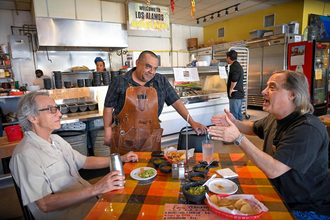 Augustin “Gus” Juarez, 53, center, who has owned Los Alamos Cocina for 22 years, talks with regular customers David Basse, left, and John Trozzolo. His restaurants sits blocks from multiple $1 million homes.
