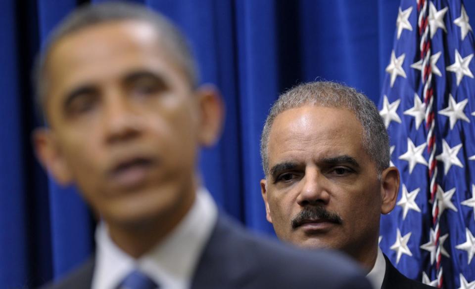 FILE - In this Feb. 9, 2012 file photo, Attorney General Eric holder listens at right as President Barack Obama speaks about a mortgage settlement in the Eisenhower Executive Office building on the White House complex in Washington. Wednesday, President Obama refused to turn over some Justice Department documents about a botched anti-smuggling operation that allowed hundreds of guns sold in Arizona to end up in Mexico. Because of the standoff, the House Government Oversight and Reform Committee then voted to hold Attorney General Eric Holder in contempt of Congress. (AP Photo/Susan Walsh)