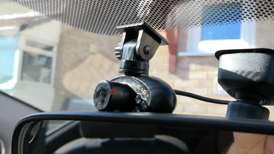 A dash cam mounted inside a car windscreen