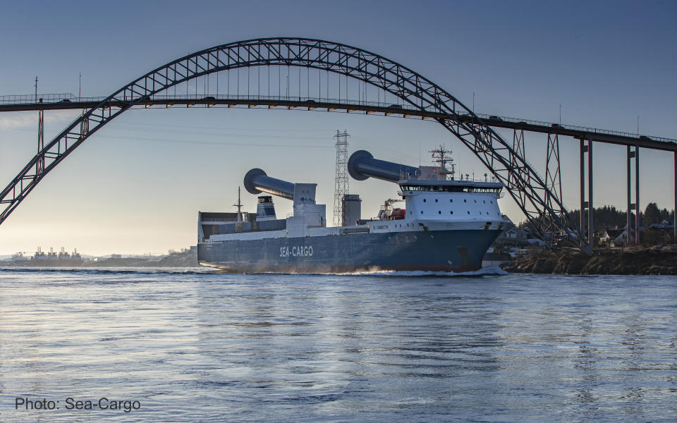 This 2021 photo shows the SC Connector, a freight-hauling vessel owned by the Norwegian company Sea-Cargo, passing beneath the Karmsund Bridge on the Karmsundet Strait in Haugesund, Norway. The ship is equipped with two rotor sails manufactured by Finland-based Norsepower. The 38-yard-high (35-meter-high) rotors spin in the wind and help propel the vessel. They also can tilt to avoid overhead bridges and power lines. It’s an example of new technologies helping the shipping industry reduce its greenhouse gas emissions. (Tor Nilssen/Sea-Cargo via AP)