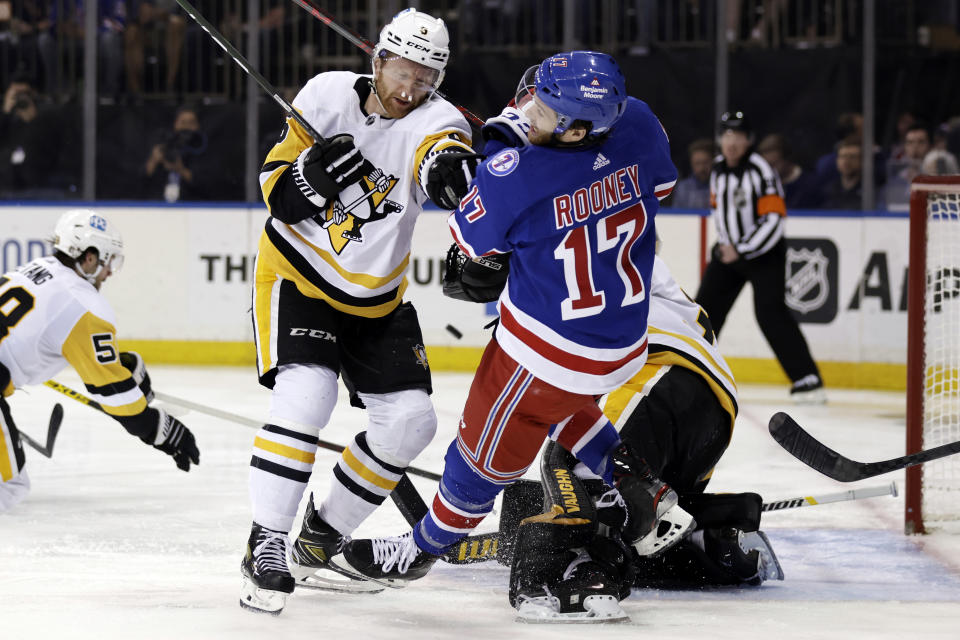 Pittsburgh Penguins defenseman Mike Matheson pushes New York Rangers center Kevin Rooney (17) to the ice during the second period in Game 7 of an NHL hockey Stanley Cup first-round playoff series, Sunday, May 15, 2022, in New York. (AP Photo/Adam Hunger)