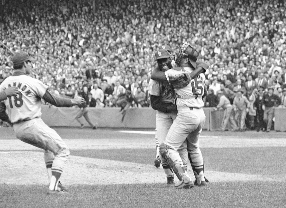 FILE - St. Louis Cardinals pitcher Bob Gibson receives a congratulatory hug from catcher Tim McCarver after he pitched a three-hit, 7-2 victory in Game 7 over the Boston Red Sox to win the 1967 World Series at Fenway Park, on Oct. 12, 1967 in Boston. McCarver, the All-Star catcher and Hall of Fame broadcaster who during 60 years in baseball won two World Series titles with the St. Louis Cardinals and had a long run as the one of the country's most recognized, incisive and talkative television commentators, died Thursday morning, Feb. 16, 2023, in Memphis, Tenn., due to heart failure, baseball Hall of Fame announced. He was 81. (AP Photo/File)