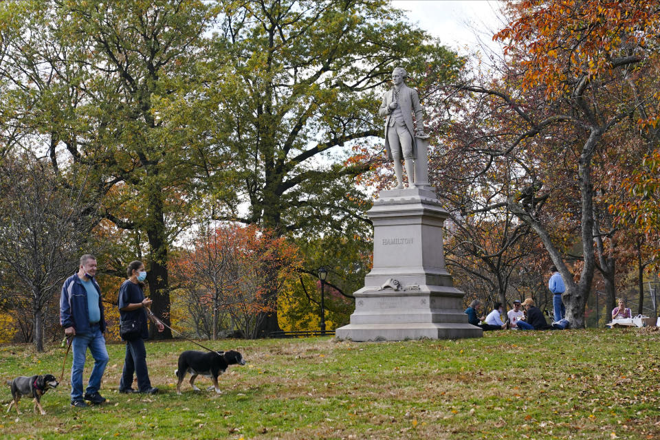 Pedestrians pass a statue of Alexander Hamilton in Central Park Tuesday, Nov. 10, 2020, in New York. (AP Photo/Frank Franklin II)