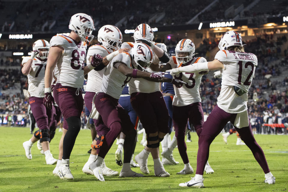 Virginia Tech players celebrate after wide receiver Da'Quan Felton (9) scored a touchdown against Virginia during the second half of an NCAA college football game Saturday, Nov. 25, 2023, in Charlottesville, Va. (AP Photo/Mike Caudill)