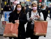 Des passantes masquées font des achats avant Noël à Bond Street dans le centre de Londres le 21 décembre 2021 (AFP/Tolga Akmen)