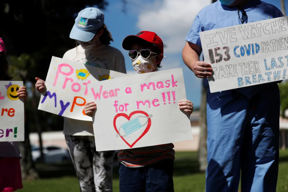 Supporters of wearing masks in schools Sofia Deyo 11, and her brother Matthew Deyo 6, protest before the special called school board workshop at the Pinellas County Schools Administration Building in Largo, Florida, U.S., August 9, 2021. REUTERS/Octavio Jones