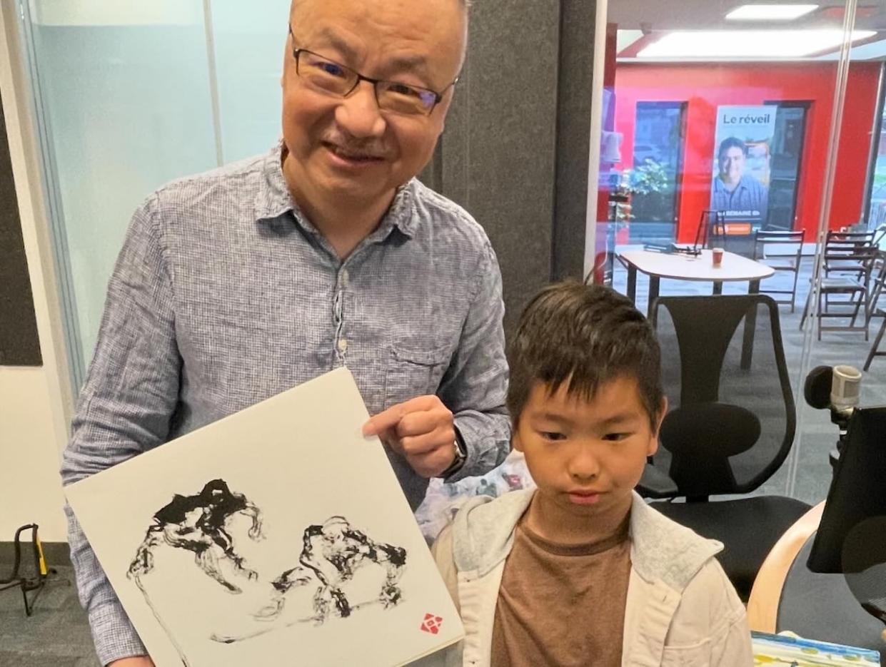 Xin and Yilang Liu pose with one of Xin's paintings on a recent interview at the CBC News studio in Charlottetown. Xin was inspired by watching Yilang play hockey. (Mitch Cormier/CBC - image credit)