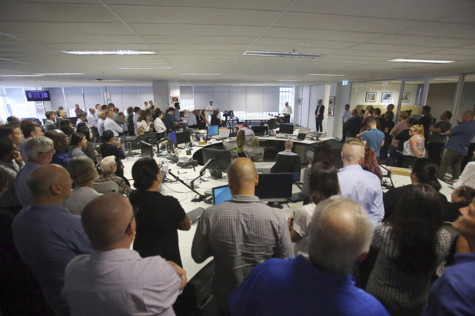 Staff at the Australian Associated Press head office gather for an announcement in Sydney, Tuesday, March 3, 2020. National news agency Australian Associated Press said it was closing after 85 years, blaming a decline in subscribers and free distribution of news content on digital platforms. (Steven Saphore/AAP Image via AP)