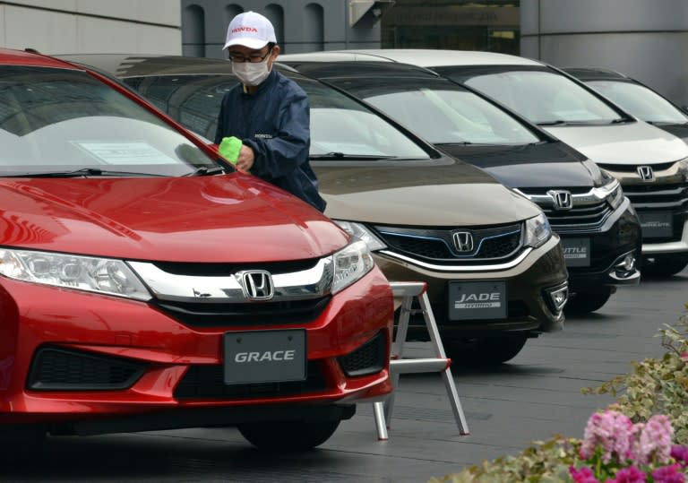 A Honda Motor employee dusts a vehicle at a Honda showroom in Tokyo on January 29, 2016