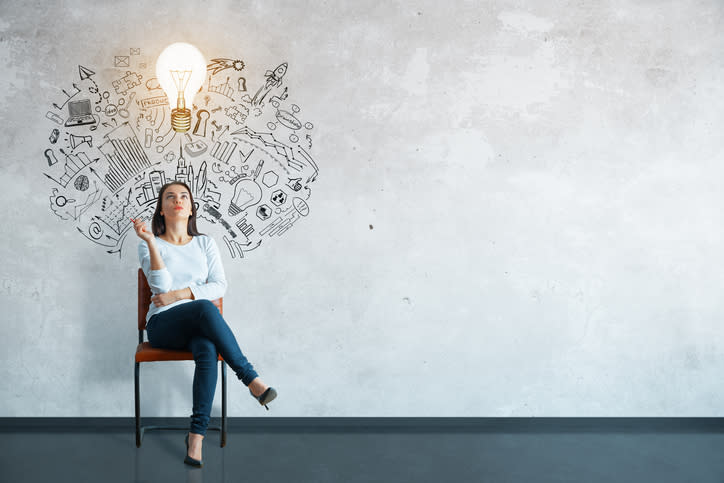 A woman sitting in a chair and a light bulb hovering overhead.