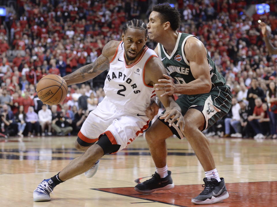 Toronto Raptors forward Kawhi Leonard (2) drives to the net around Milwaukee Bucks guard Malcolm Brogdon (13) during the second overtime period of Game 3 of the NBA basketball playoffs Eastern Conference finals in Toronto on Sunday, May 19, 2019. (Nathan Denette/The Canadian Press via AP)