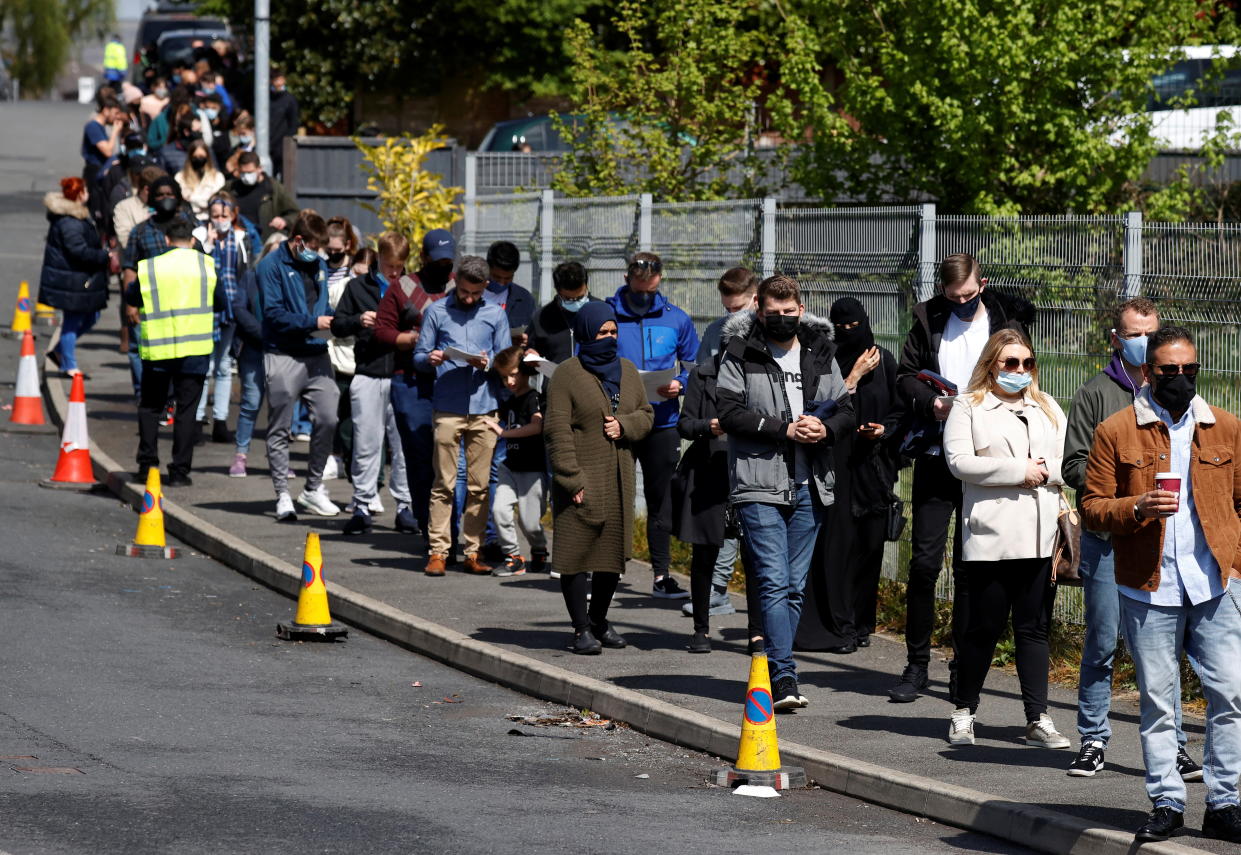 People line up outside a mobile vaccination centre, amid the outbreak of the coronavirus disease (COVID-19) in Bolton, Britain, May 16, 2021. REUTERS/Phil Noble