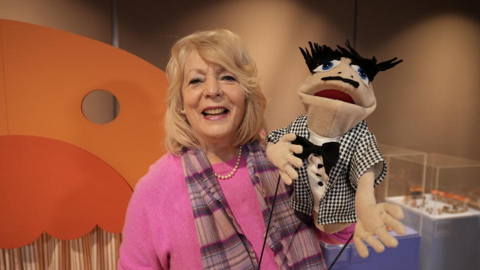 Alison Steadman in a pink jumper holds a puppet in Alison & Larry: Billericay to Barry.
