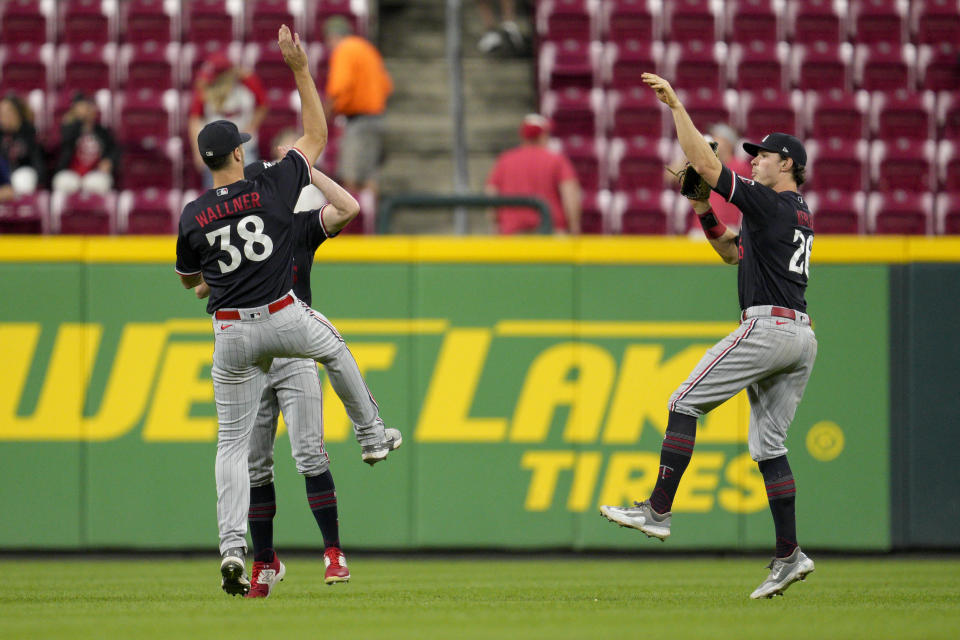 Minnesota Twins' Matt Wallner (38), Andrew Stevenson and Max Kepler (26) celebrate after a baseball game against the Cincinnati Reds in Cincinnati, Tuesday, Sept. 19, 2023. (AP Photo/Jeff Dean)