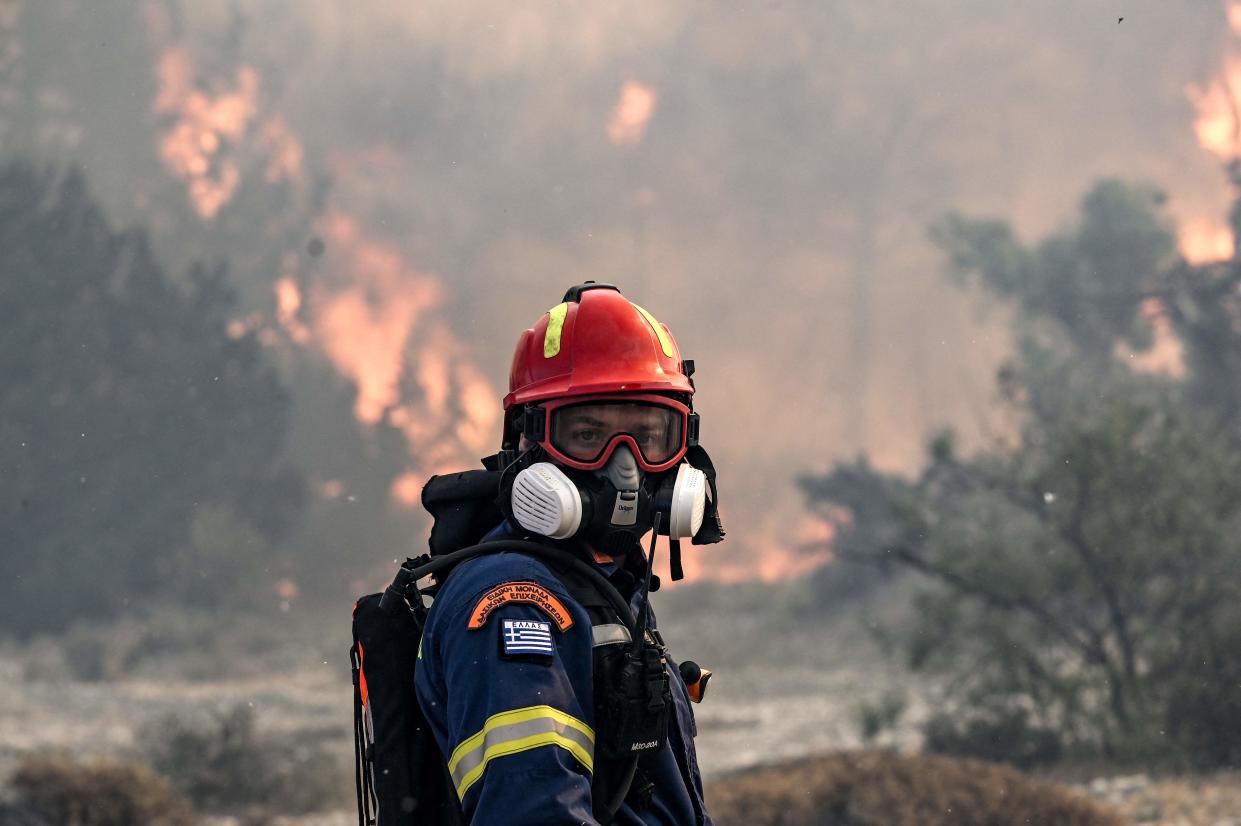 A firefighter looks on during a fire near the village of Vati, just north of the coastal town of Gennadi (AFP via Getty Images)