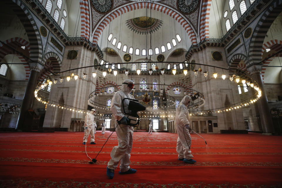 Municipality workers disinfect the grounds of the historical Suleymaniye Mosque, in Istanbul, during the third day of Eid el-Fitr and the last day of a four-day curfew due to the coronavirus outbreak, Tuesday, May 26, 2020. Istanbul's municipality workers disinfected several mosques which were locked down for more than six weeks and will be partly open again for prayers on Friday, May 29. The Muslim holiday marking the end of the fasting month of Ramadan, traditionally a time of gathering, was marked by a nationwide lockdown to combat the coronavirus. (AP Photo/Emrah Gurel)