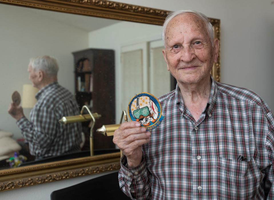 Morris Drees holds a squadron patch from when he was a naval aviator as he talks about his experiences at his home in Gulf Breeze.