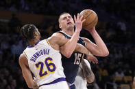 Denver Nuggets center Nikola Jokic, right, is fouled by Los Angeles Lakers guard Spencer Dinwiddie as he tries to shoot during the first half in Game 4 of an NBA basketball first-round playoff series Saturday, April 27, 2024, in Los Angeles. (AP Photo/Mark J. Terrill)