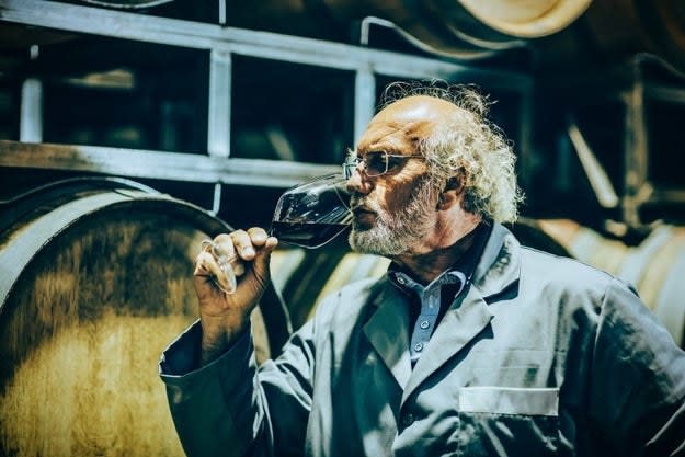 A man tasting a glass of wine.