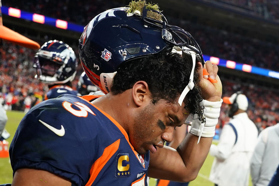 Denver Broncos quarterback Russell Wilson (3) removes his helmet after a concussion against the Kansas City Chiefs during the second half of an NFL football game, Sunday, Dec. 11, 2022, in Denver. (AP Photo/Jack Dempsey)