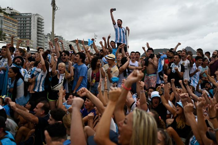 Fans of Argentina react while watching the live broadcast of the Qatar 2022 World Cup final football match between France and Argentina at the Copacabana beach in Rio de Janeiro, Brazil, on December 18, 2022. (Photo by MAURO PIMENTEL / AFP) (Photo by MAURO PIMENTEL/AFP via Getty Images)