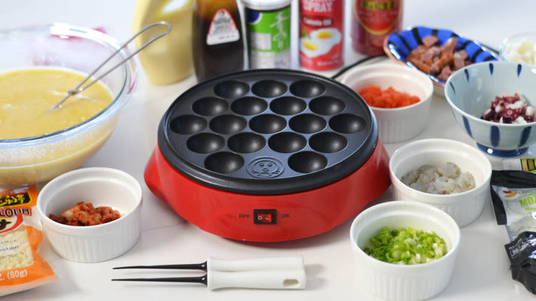 Takoyaki station, with a takoyaki maker in the center surrounded by ingredients