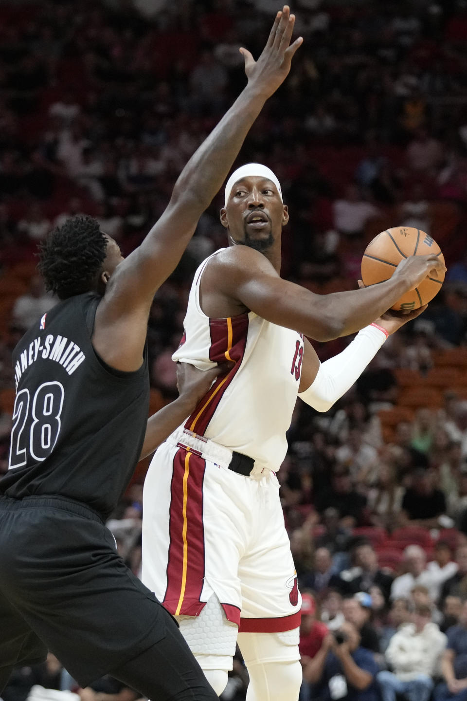 Miami Heat center Bam Adebayo, right, looks for an open teammate past Brooklyn Nets forward Dorian Finney-Smith (28) during the first half of an NBA basketball game, Wednesday, Nov. 1, 2023, in Miami. (AP Photo/Wilfredo Lee)