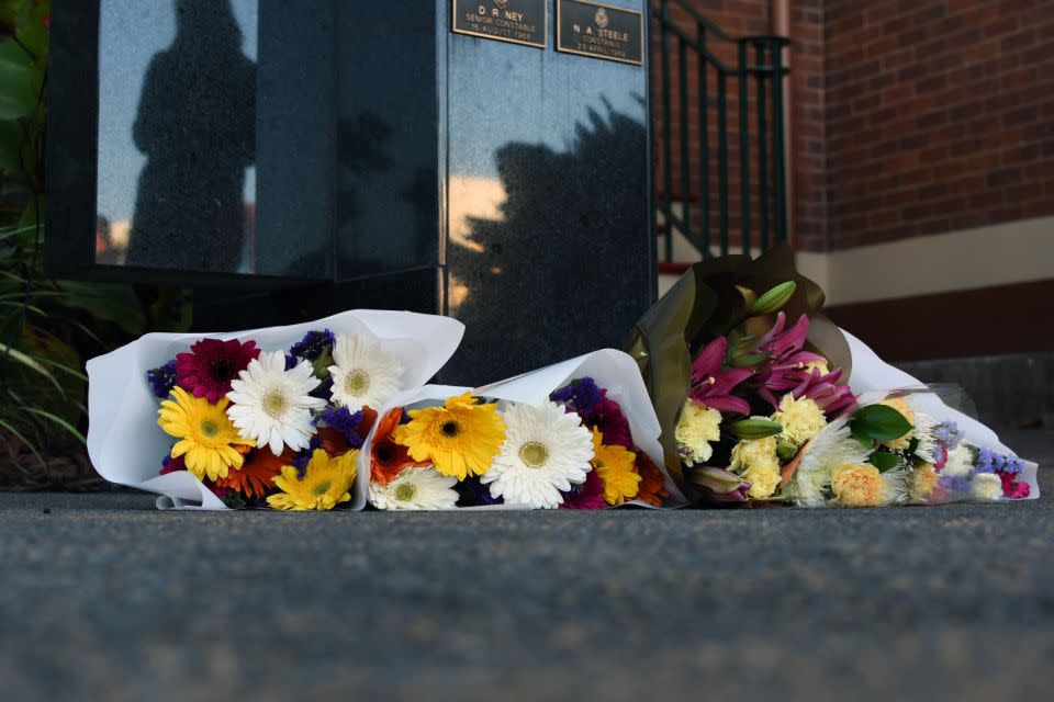 Mourners lay flowers outside Toowoomba police station. Photo: AAP