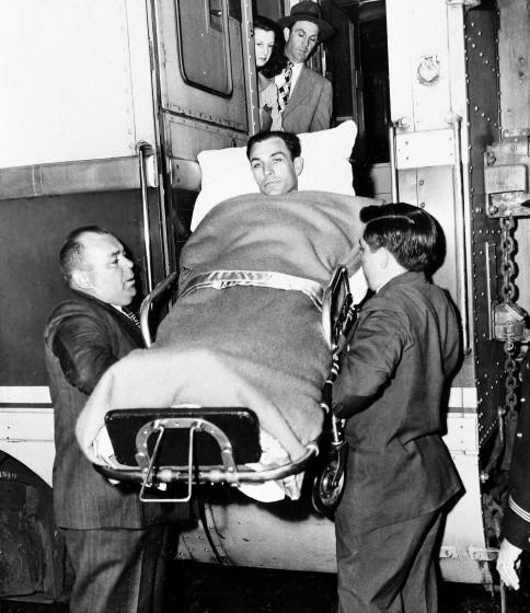 Golfer Ben Hogan of Fort Worth is ushered from train in which he made his trip back to Fort Worth.