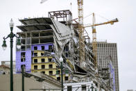 Debris hangs on the side of the building after a large portion of a hotel under construction suddenly collapsed in New Orleans on Saturday, Oct. 12, 2019. Several construction workers had to run to safety as the Hard Rock Hotel, which has been under construction for the last several months, came crashing down. It was not immediately clear what caused the collapse or if anyone was injured. (Scott Threlkeld/The Advocate via AP)