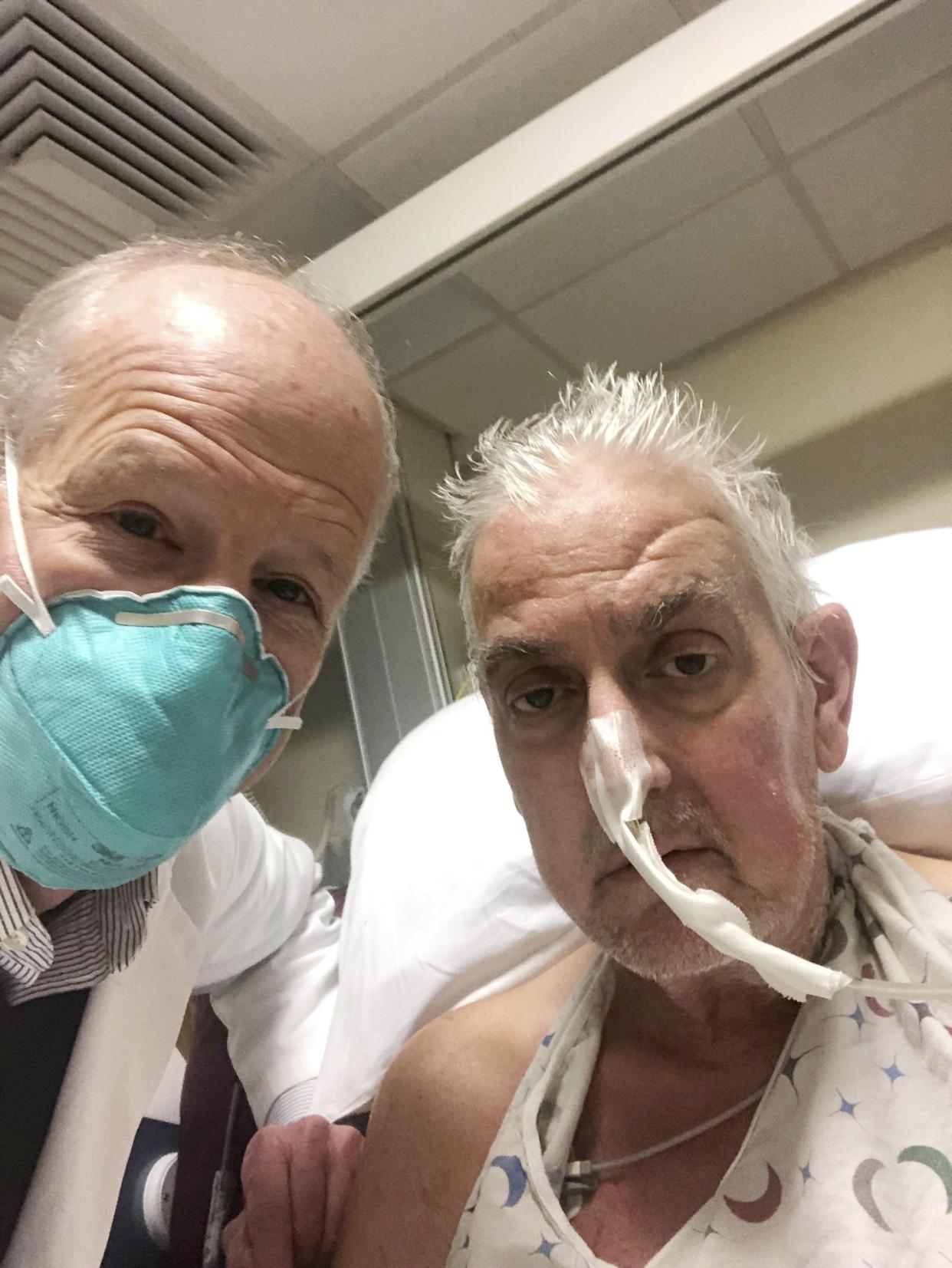 In this photo provided by the University of Maryland School of Medicine, Dr. Bartley Griffith takes a selfie photo with patient David Bennett in Baltimore in January 2022. 