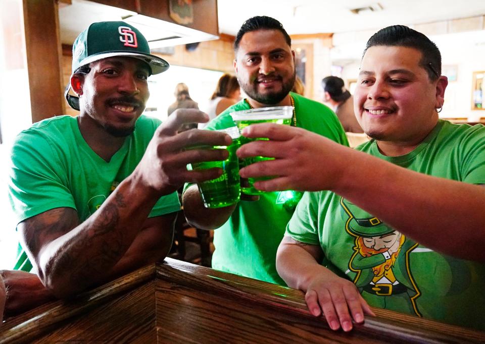 Darryl Fisher, Victor Solares, and Noel Hernandez (right) celebrate St. Patrick's Day at Seamus McCaffrey's Irish Pub and Restaurant in downtown Phoenix, March 17, 2021.