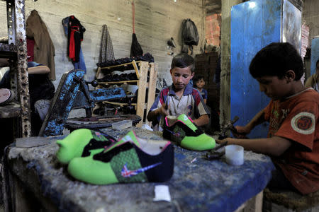 Children make sports shoes in a sweat shop in government-controlled al-Hamadaniah district of Aleppo, Syria July 12, 2017. Picture taken July 12, 2017. REUTERS/Omar Sanadiki