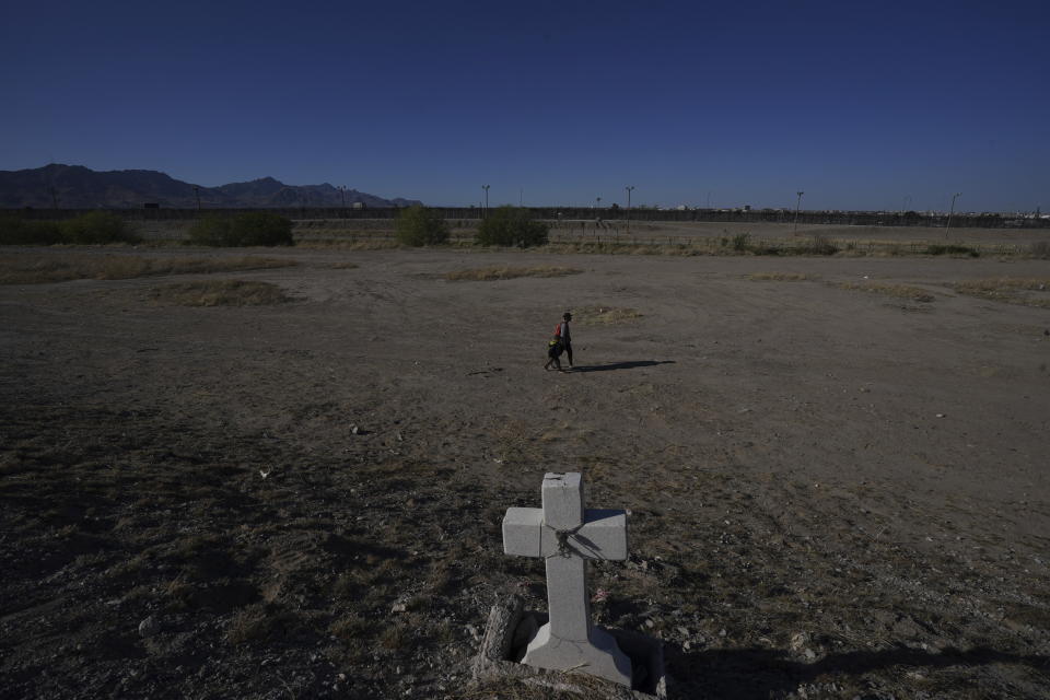 Migrants walk along the Mexico-U.S. border in Ciudad Juarez, Mexico, Wednesday, March 29, 2023, a day after dozens of migrants died in a fire at a migrant detention center in Ciudad Juarez. (AP Photo/Fernando Llano)