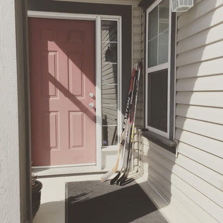 Hockey sticks are seen on a porch in tribute to the 15 youth players and personnel killed in a bus crash, in Calgary, Alberta, Canada April 9, 2018 in this picture obtained from social media. INSTAGRAM/@IAMCLARKMAN via REUTERS