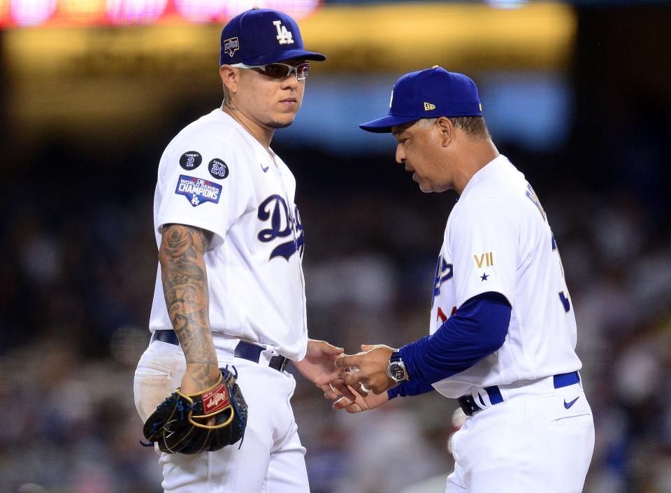 Los Angeles Dodgers manager Dave Roberts, right, takes the ball from starting pitcher Julio Urias during a 2021 game.