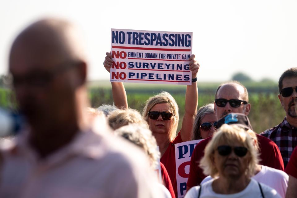 Landowners hold signs during a press conference by opponents of the Summit Carbon Solutions pipeline on Tuesday, August 22, 2023 in Fort Dodge.