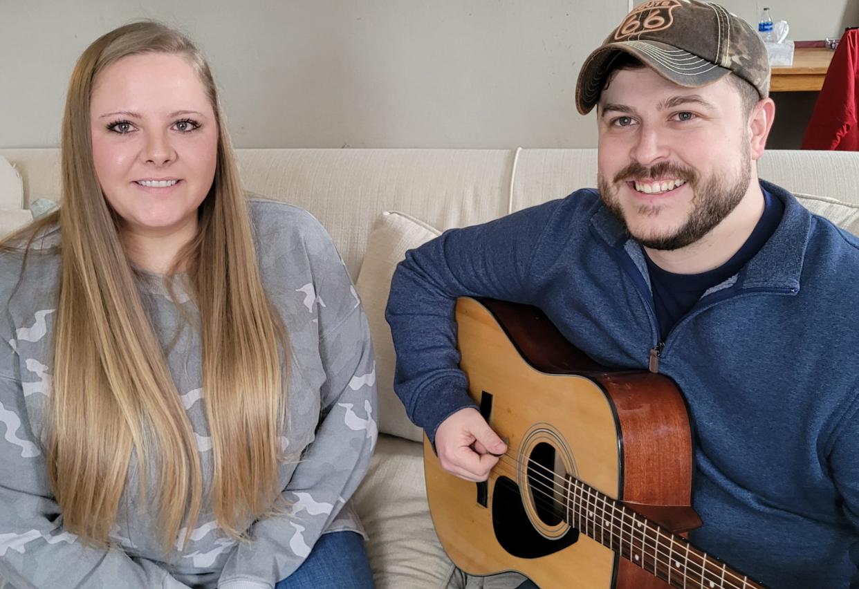 Sarah Stauffer listens while husband Jeff plays his guitar in their Loudonville living room. Stauffer may have received his big break in country music with a song cover he posted on TikTok that has had 1.4 million views.