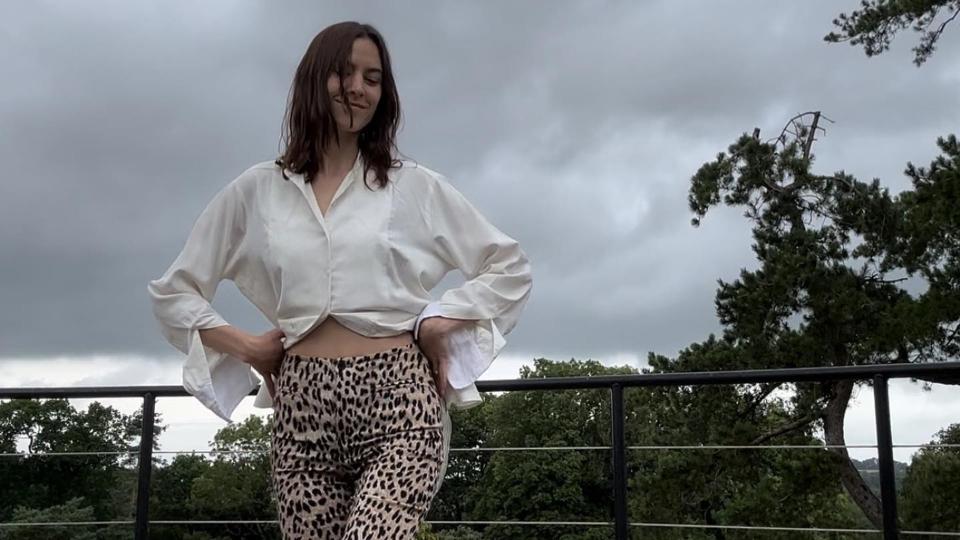 Alexa Chung poses in leopard print pants and a white blouse